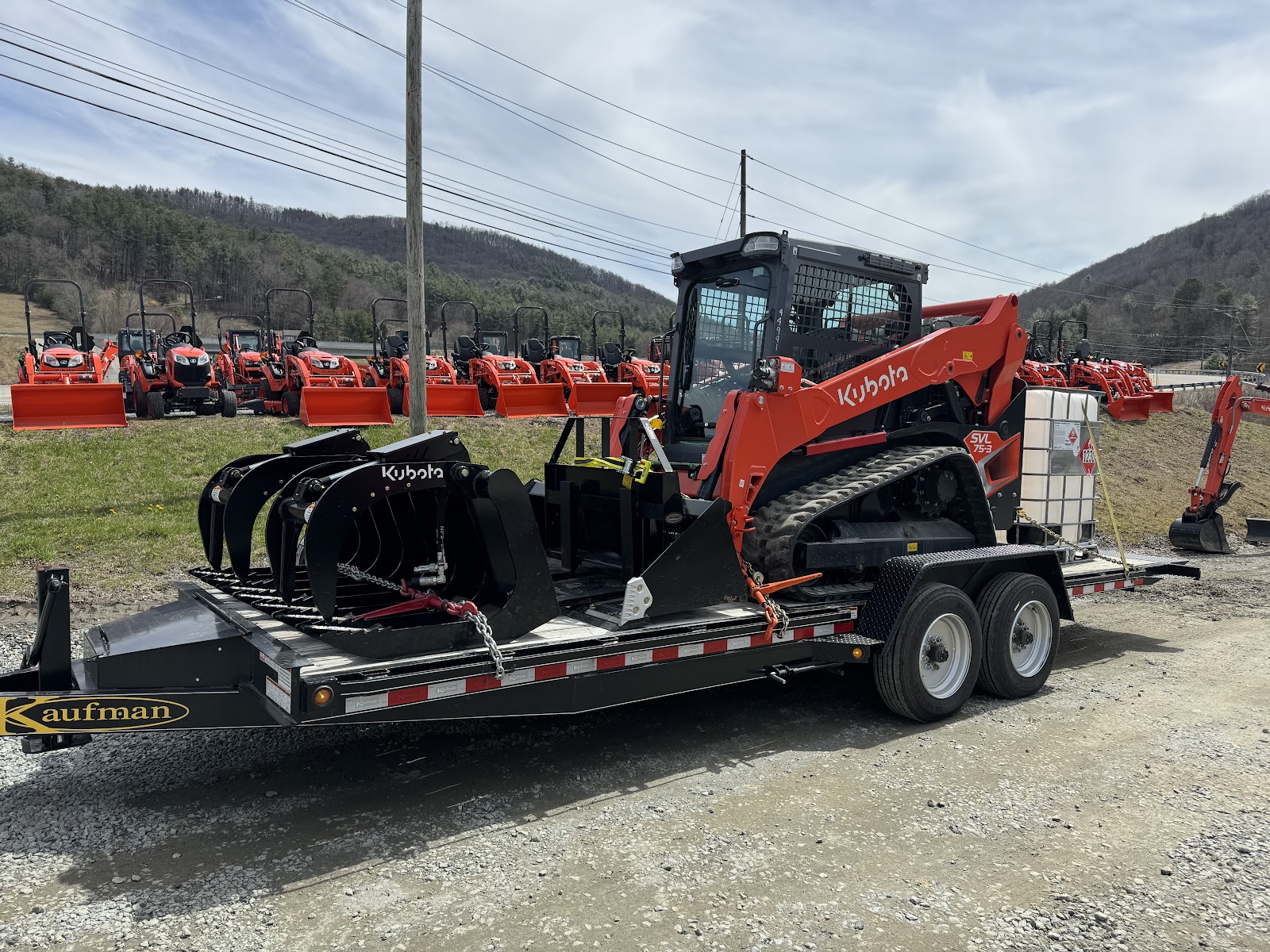 Riverfront Group red Kubota skid steer on trailer, excavation equipment