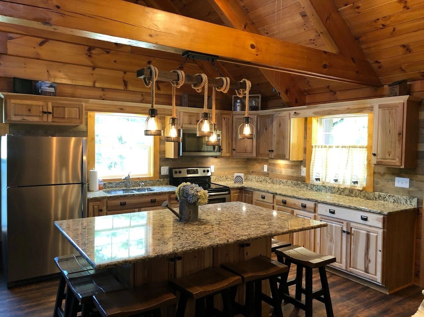 Log cabin kitchen remodel with custom hickory cabinetry and granite island, completed by Riverfront Group