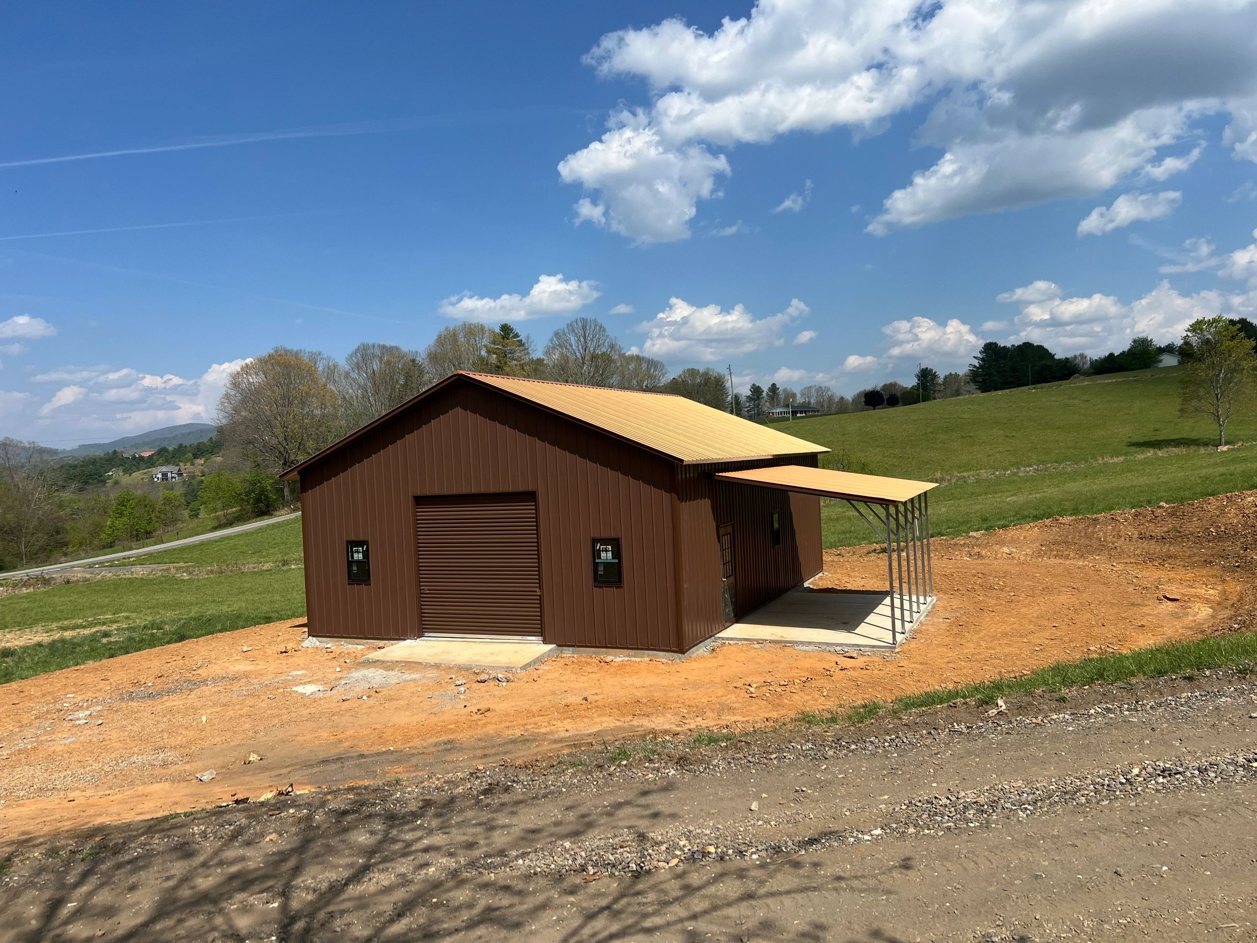 Brown metal pole barn and garage building with mountain views