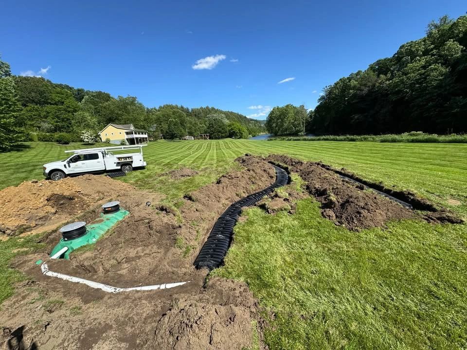 Riverfront Group crew completing a septic system installation on a High Country property, mountains in the background